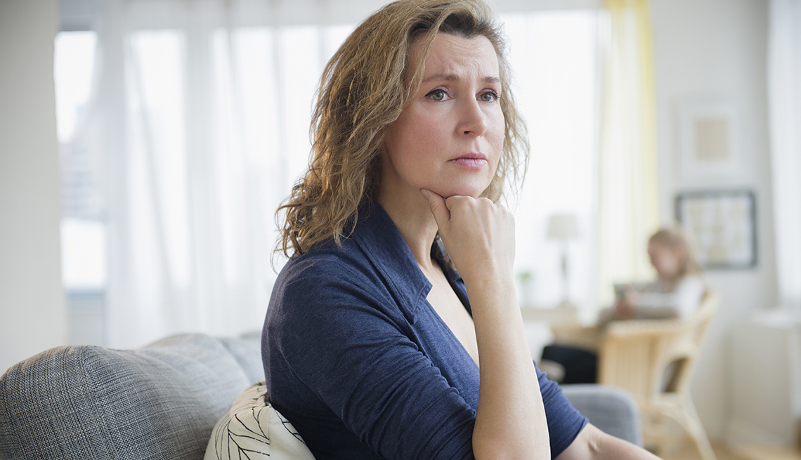 Concerned Caucasian woman sitting on sofa